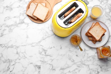 Photo of Toaster with roasted bread, glass of juice and jam on white marble table, flat lay. Space for text