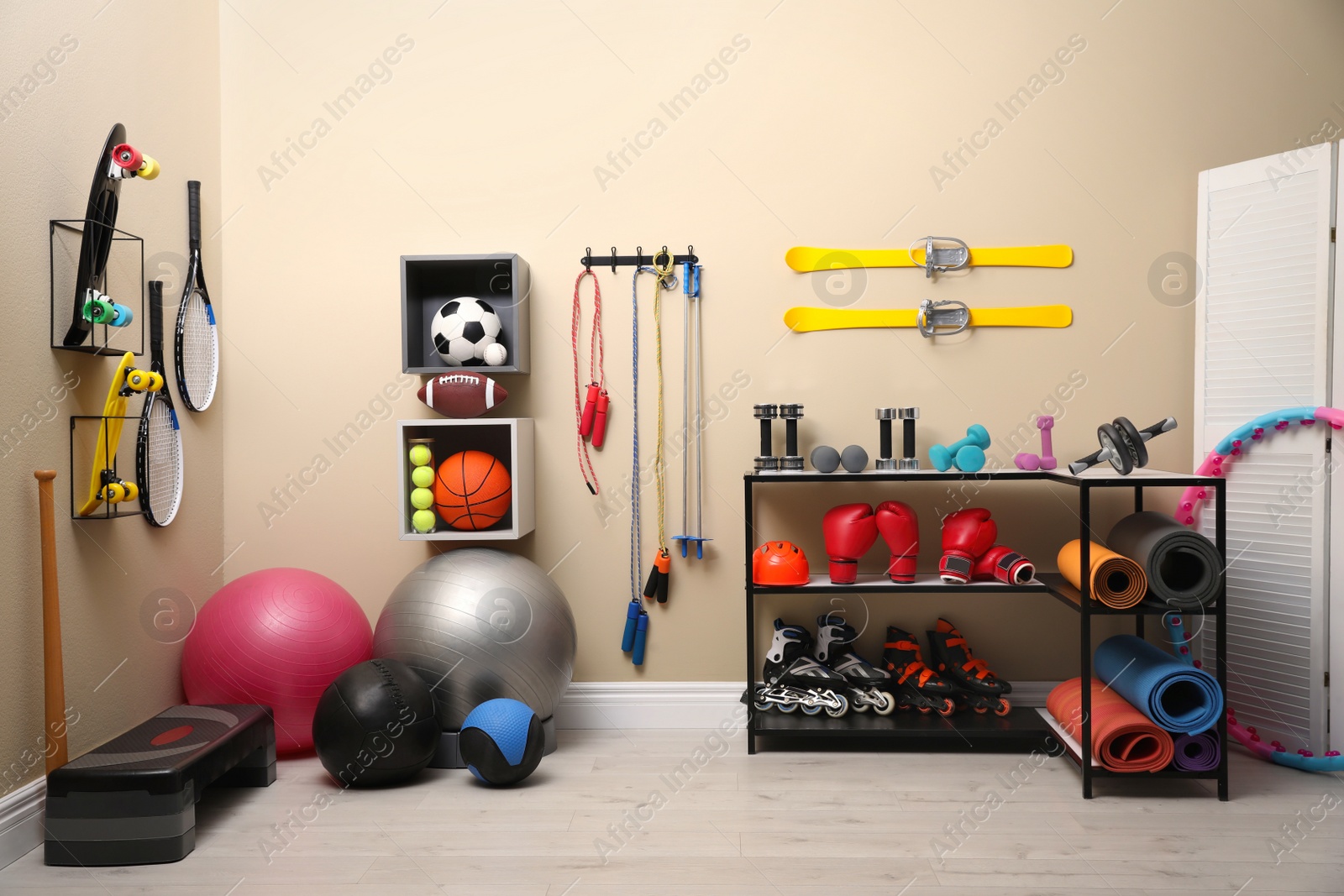 Photo of Many different sports equipment in room with beige walls