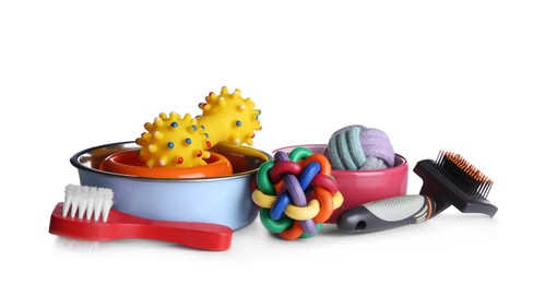 Photo of Feeding bowls, brushes and dog toys on white background