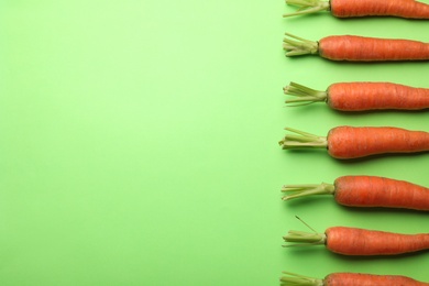 Photo of Flat lay composition with fresh carrots on color background. Space for text