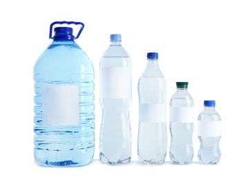 Photo of Different bottles of pure water with blank tags on white background