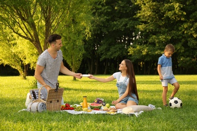 Happy family having picnic in park on sunny summer day