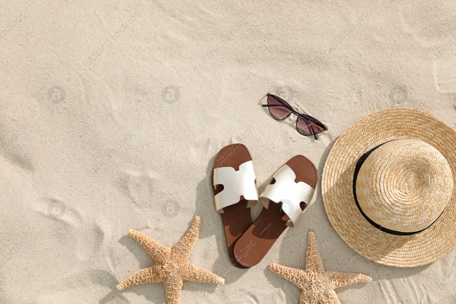 Photo of Flat lay composition with beach accessories on sand. Space for text