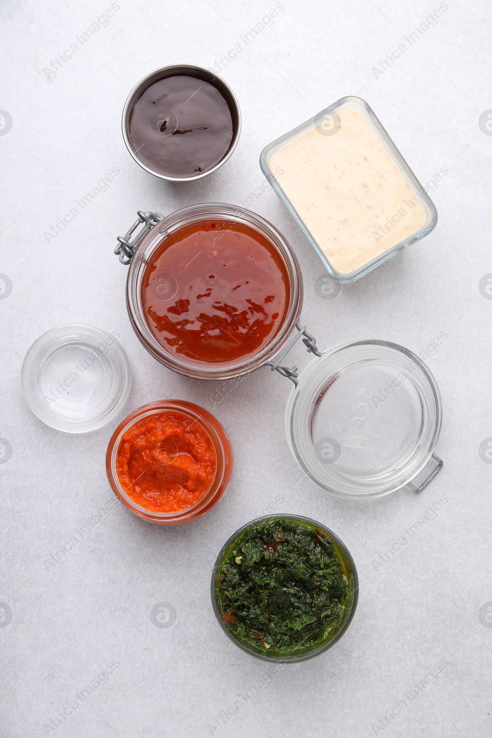 Photo of Different marinades on light table, flat lay