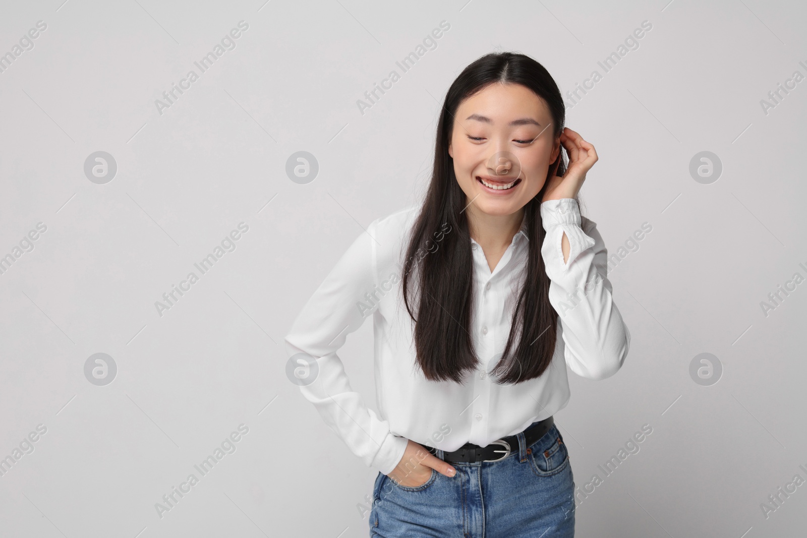 Photo of Portrait of smiling woman on light background. Space for text