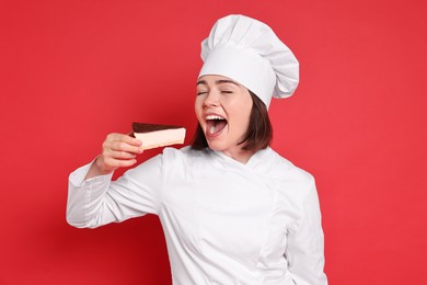 Photo of Happy confectioner eating cheesecake on red background