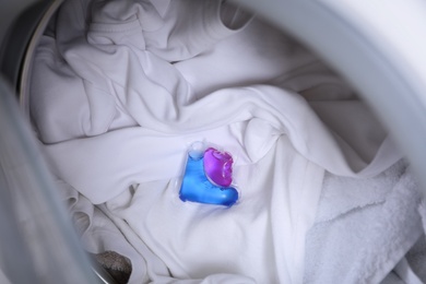 Photo of Laundry detergent capsule in washing machine drum, closeup view
