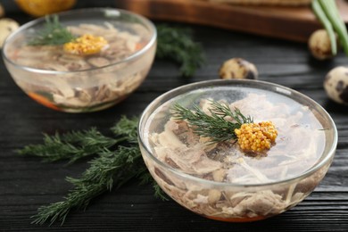 Photo of Delicious aspic with meat served on black wooden table