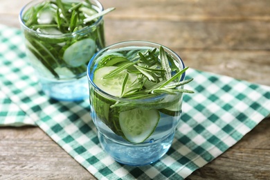 Photo of Natural lemonade with cucumber in glasses on table