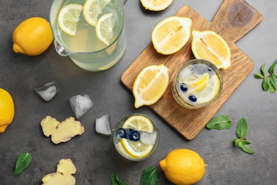 Photo of Flat lay composition with delicious natural lemonade on gray background