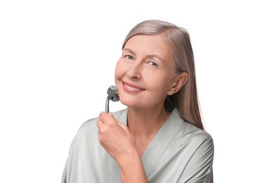 Photo of Woman massaging her face with metal roller isolated on white