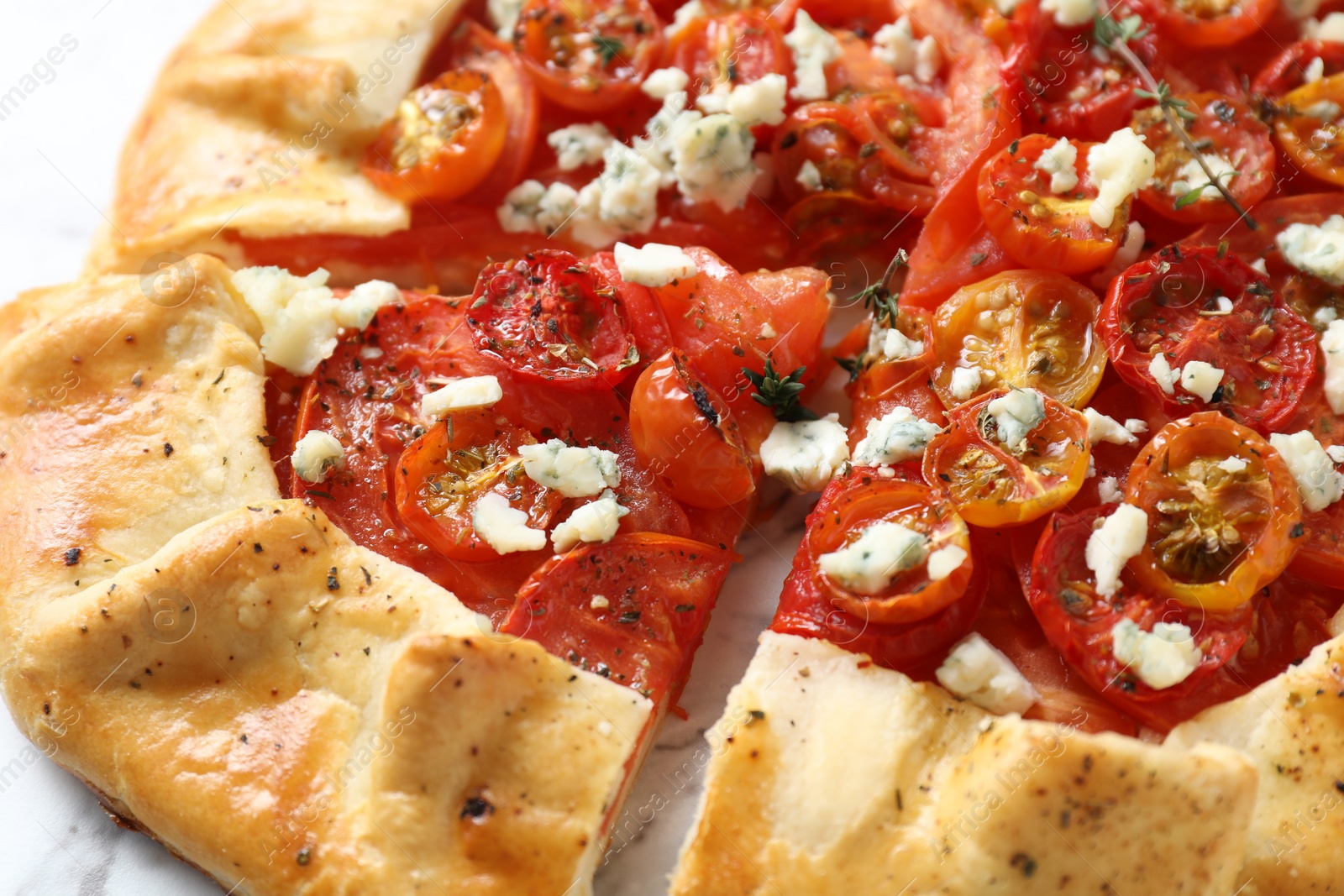 Photo of Tasty galette with tomato, thyme and cheese (Caprese galette) on table, closeup