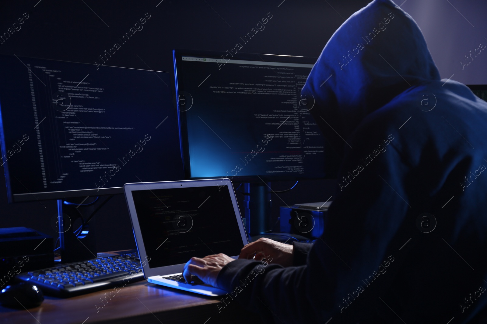 Photo of Hacker with computers in dark room. Cyber crime