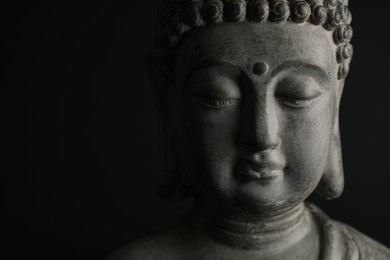 Photo of Beautiful stone Buddha sculpture on black background, closeup. Space for text