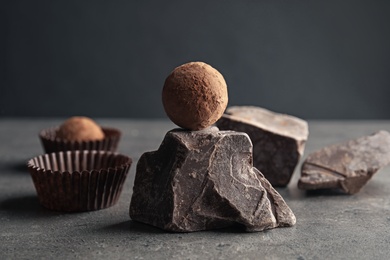 Photo of Tasty raw truffle and chocolate lump on grey table