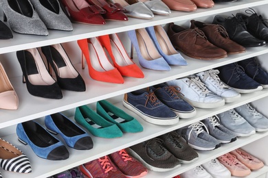 Photo of Shelving unit with different shoes. Element of dressing room interior