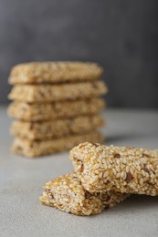 Tasty sesame seed bars on grey table, closeup