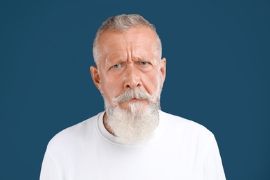 Portrait of handsome senior man on blue background