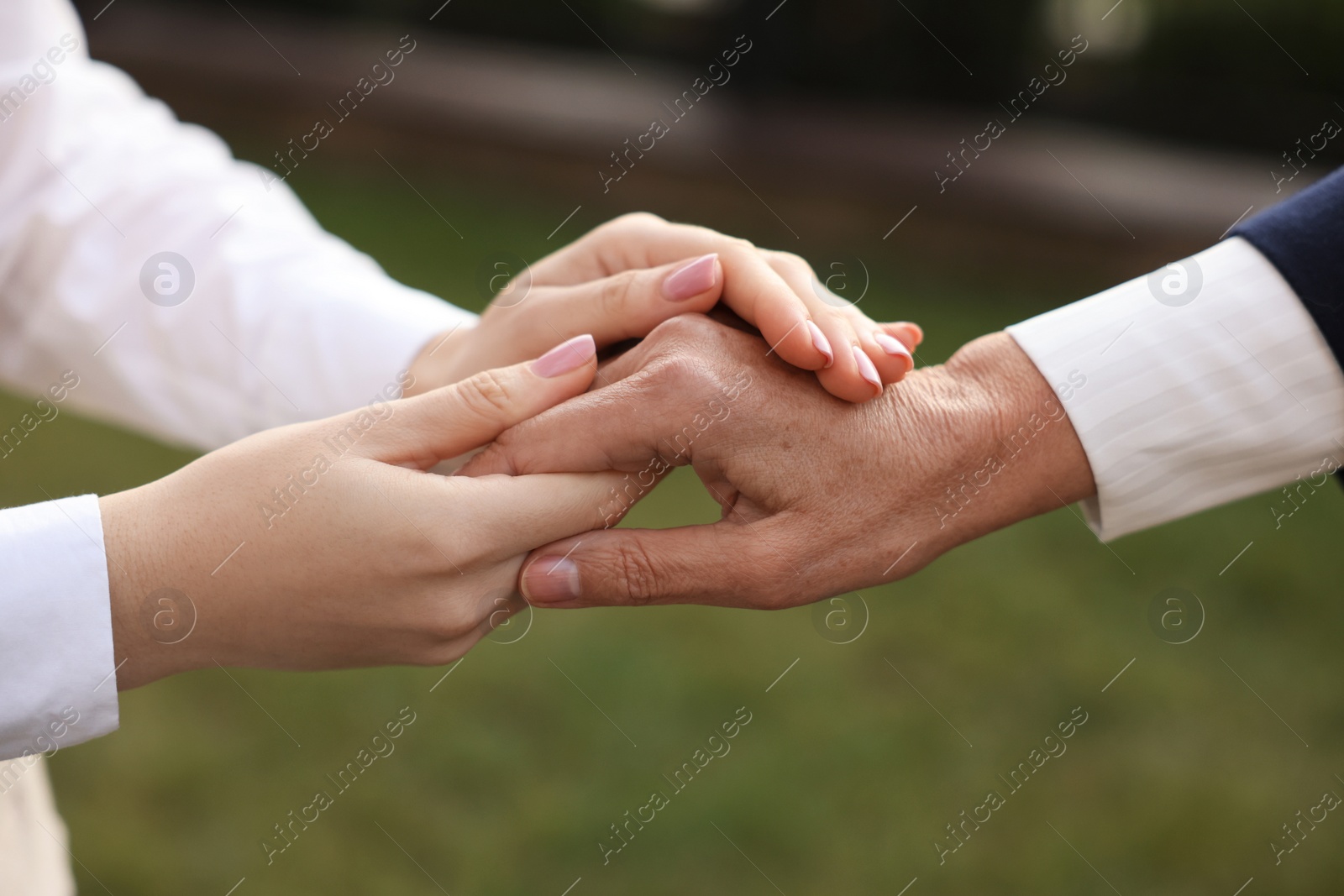 Photo of Trust and support. Women joining hands outdoors, closeup