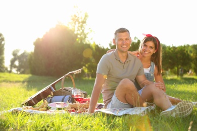 Happy couple having picnic in park on sunny day