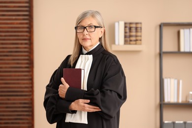 Photo of Portrait of judge in court dress with book indoors