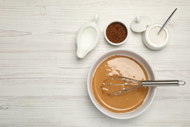 Photo of Whipping cream for dalgona coffee and ingredients on white wooden table, flat lay. Space for text