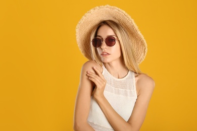 Photo of Beautiful woman in stylish sunglasses on yellow background