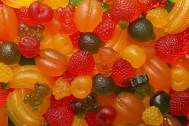 Mix of different delicious gummy candies as background, top view