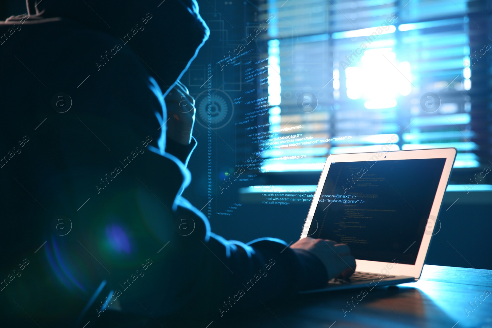 Image of Hacker working with laptop at table indoors. Cyber attack