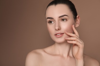 Portrait of beautiful young woman on brown background. Space for text