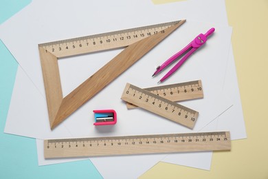 Different rulers and compass on color background, flat lay