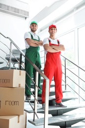 Portrait of male movers in uniform indoors