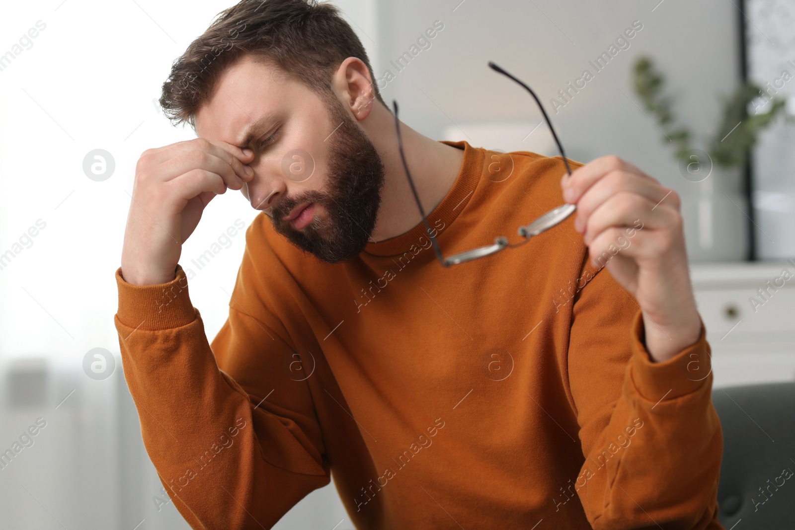 Photo of Overwhelmed man with glasses suffering at home