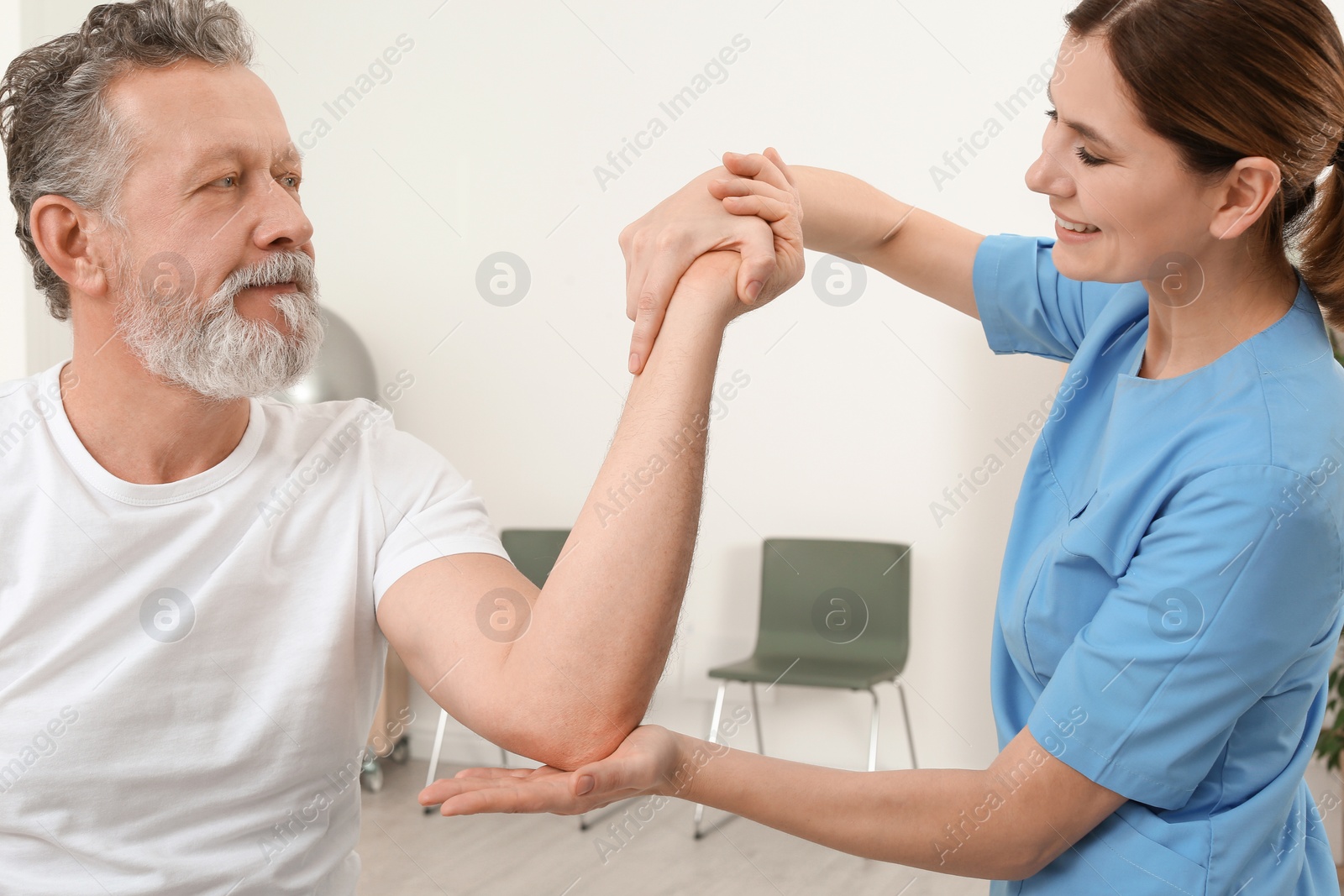 Photo of Physiotherapist working with patient in clinic. Rehabilitation therapy