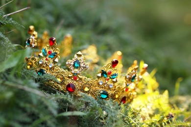 Photo of Beautiful golden crown on fresh green grass, closeup. Fantasy item