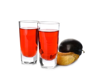 Delicious plum liquor and ripe fruits on white background. Homemade strong alcoholic beverage