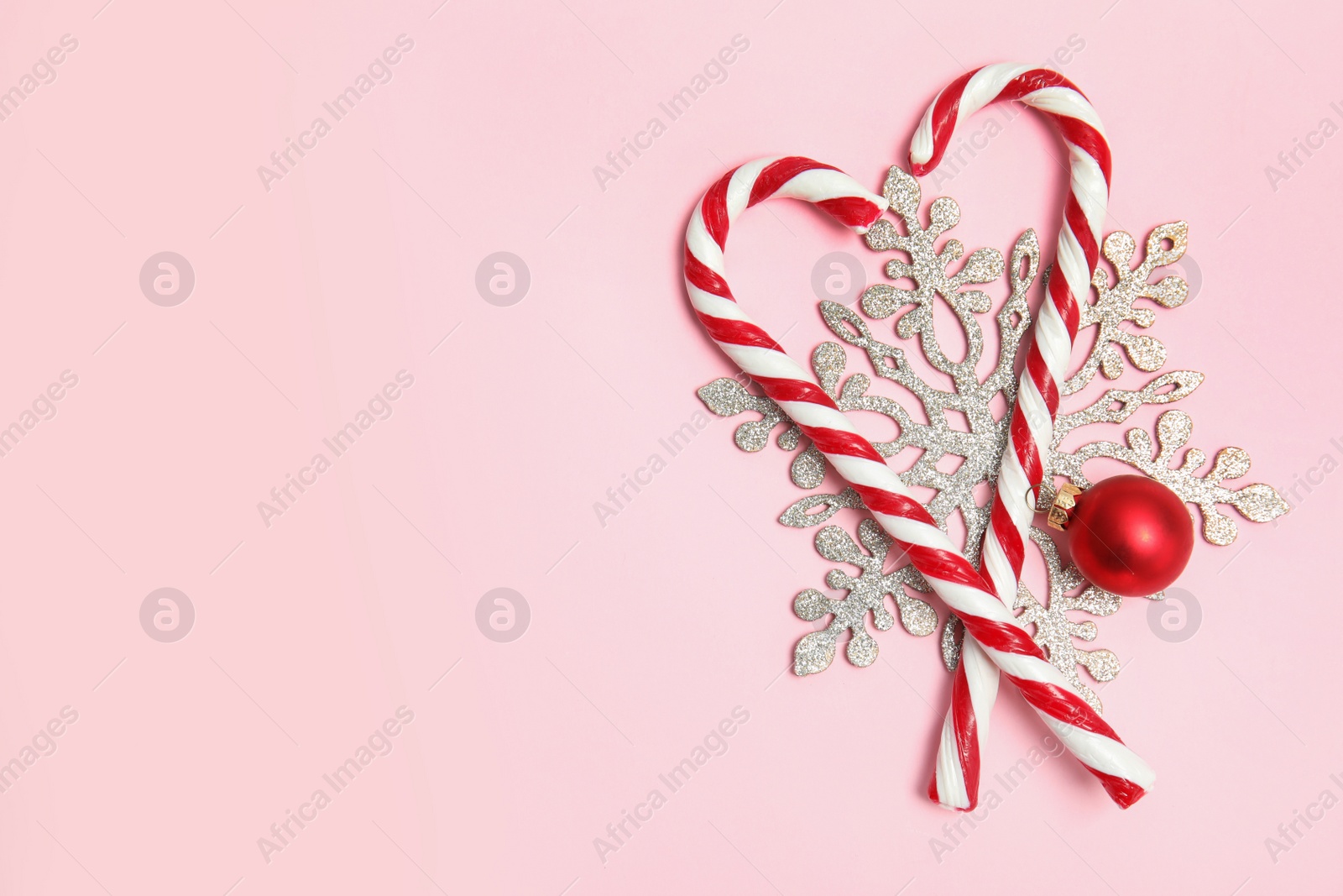 Photo of Flat lay composition with tasty candy canes and space for text on color background