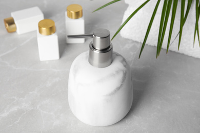 Modern marble soap dispenser on light table