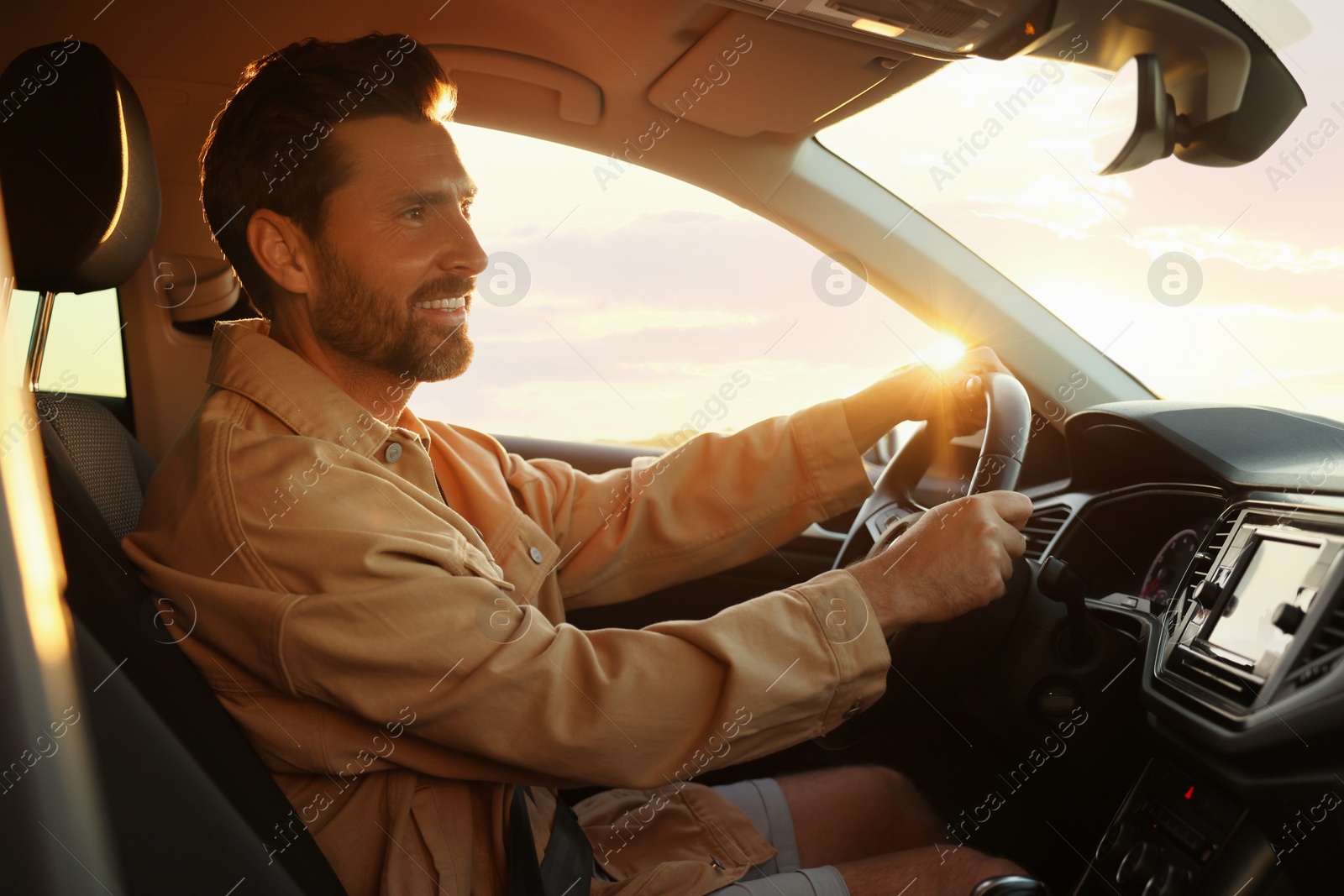 Photo of Happy bearded man sitting in his car. Enjoying trip