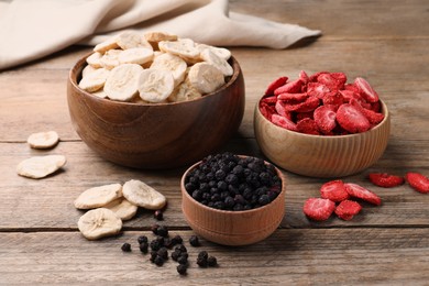 Photo of Bowls and dried fruits on wooden table
