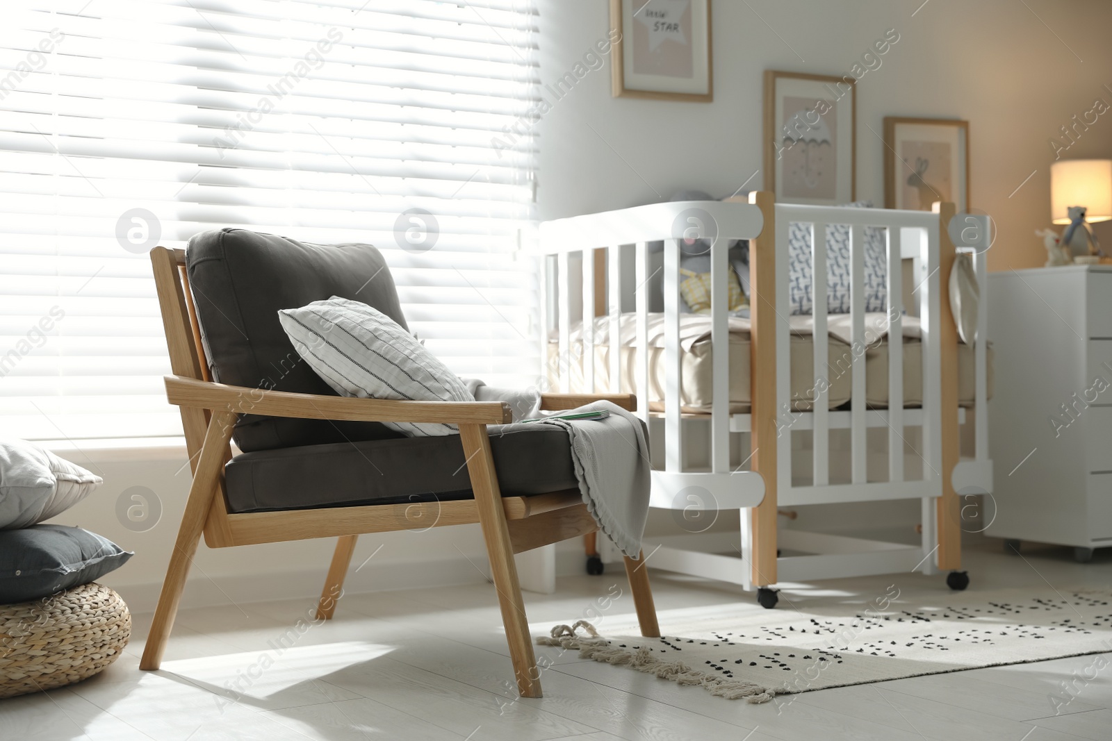 Photo of Baby room interior with crib and armchair. Idea for design