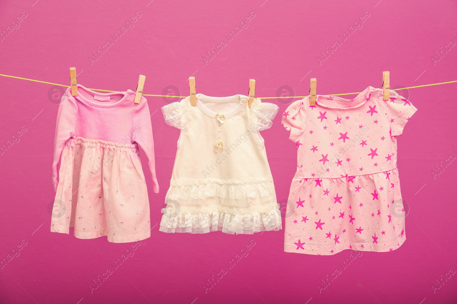 Photo of Children's clothes on laundry line against color background