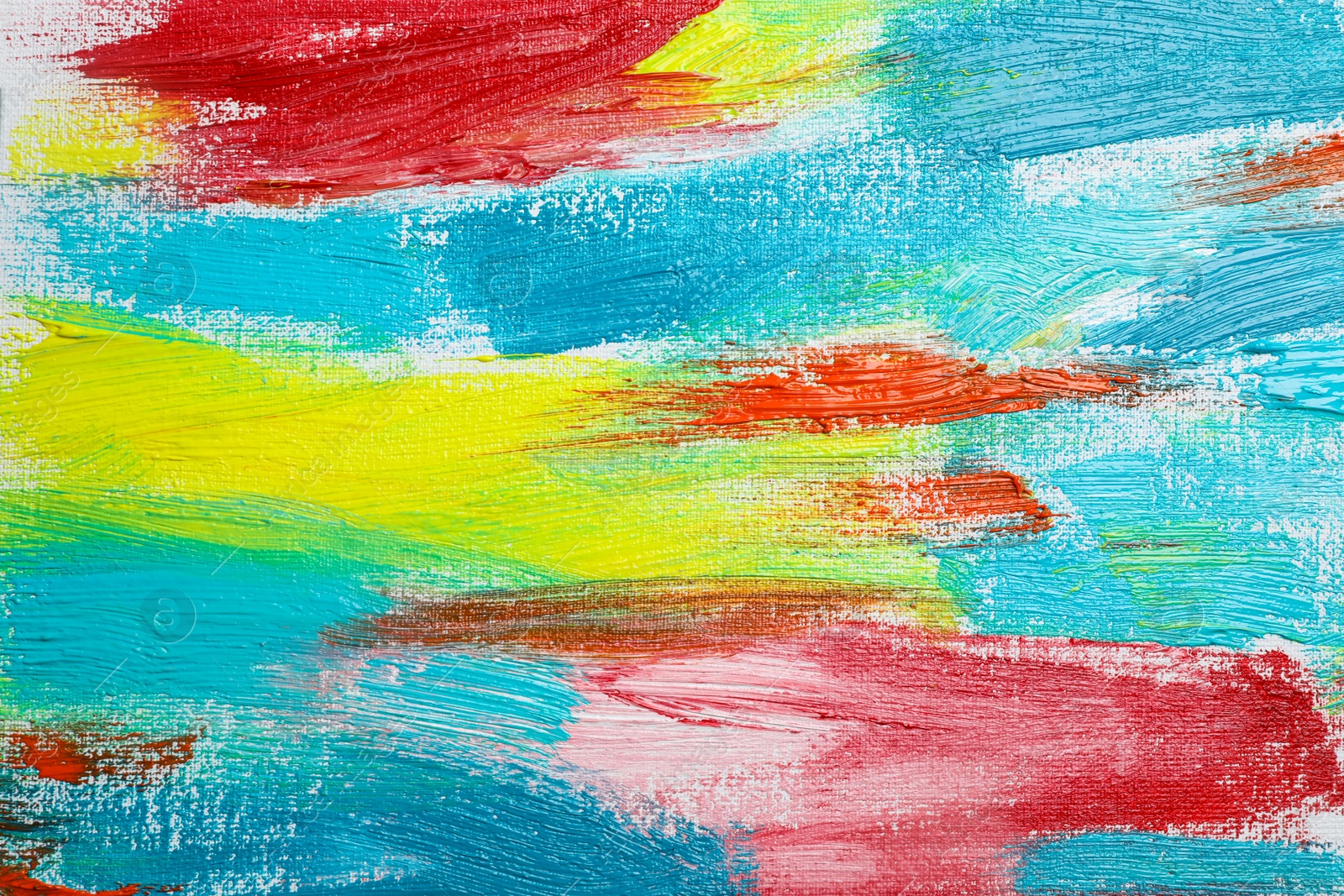 Photo of Strokes of colorful acrylic paints on canvas, closeup