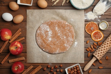 Flat lay composition with raw rye dough and ingredients on wooden background