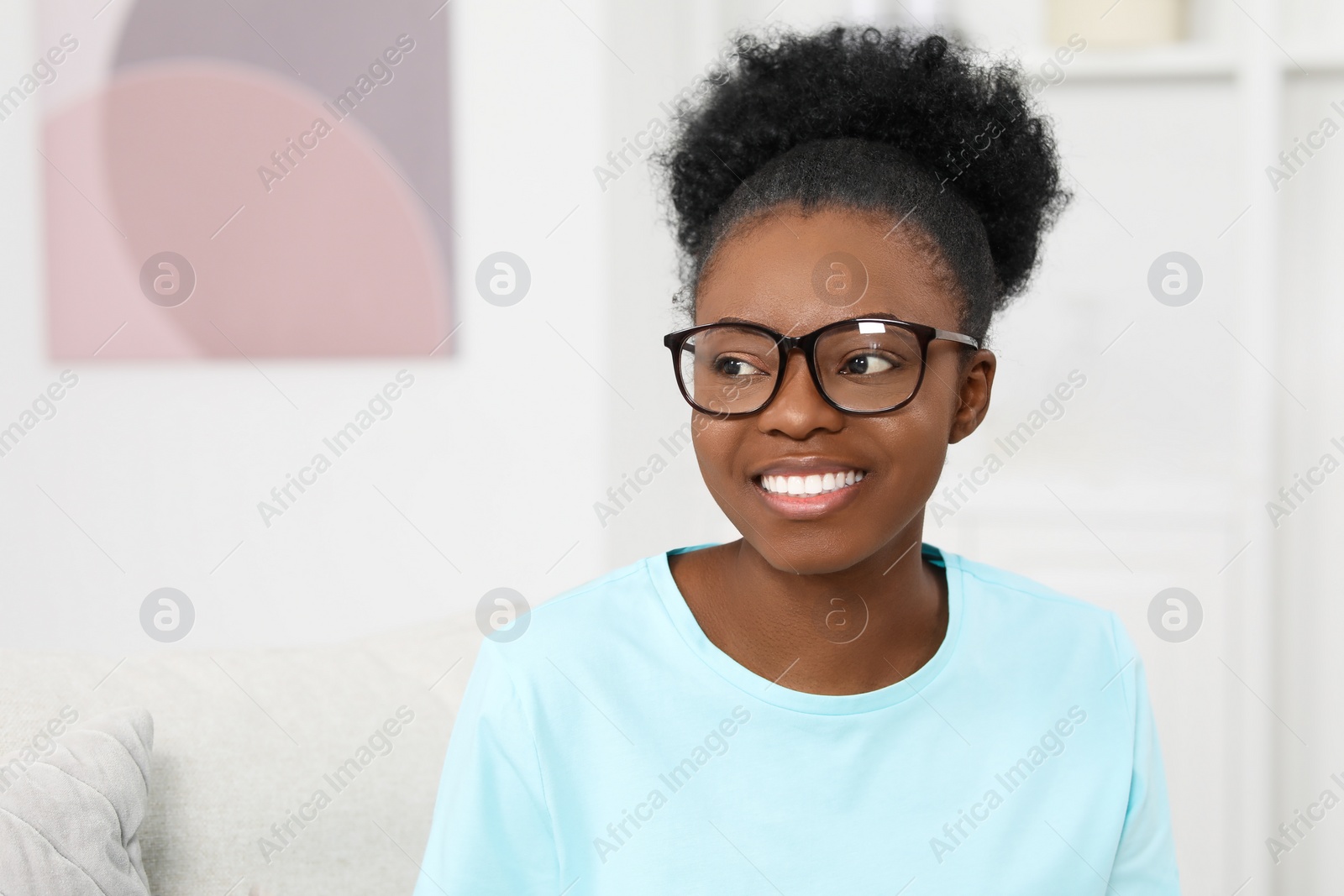 Photo of Portrait of beautiful young woman in eyeglasses at home. Space for text