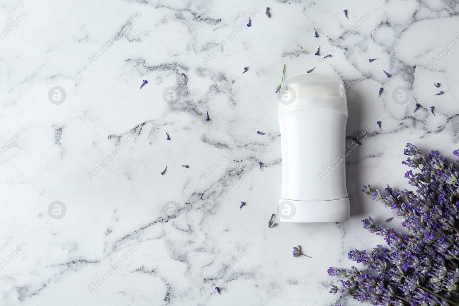 Photo of Female deodorant and lavender flowers on white marble background, flat lay. Space for text