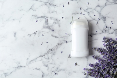 Photo of Female deodorant and lavender flowers on white marble background, flat lay. Space for text