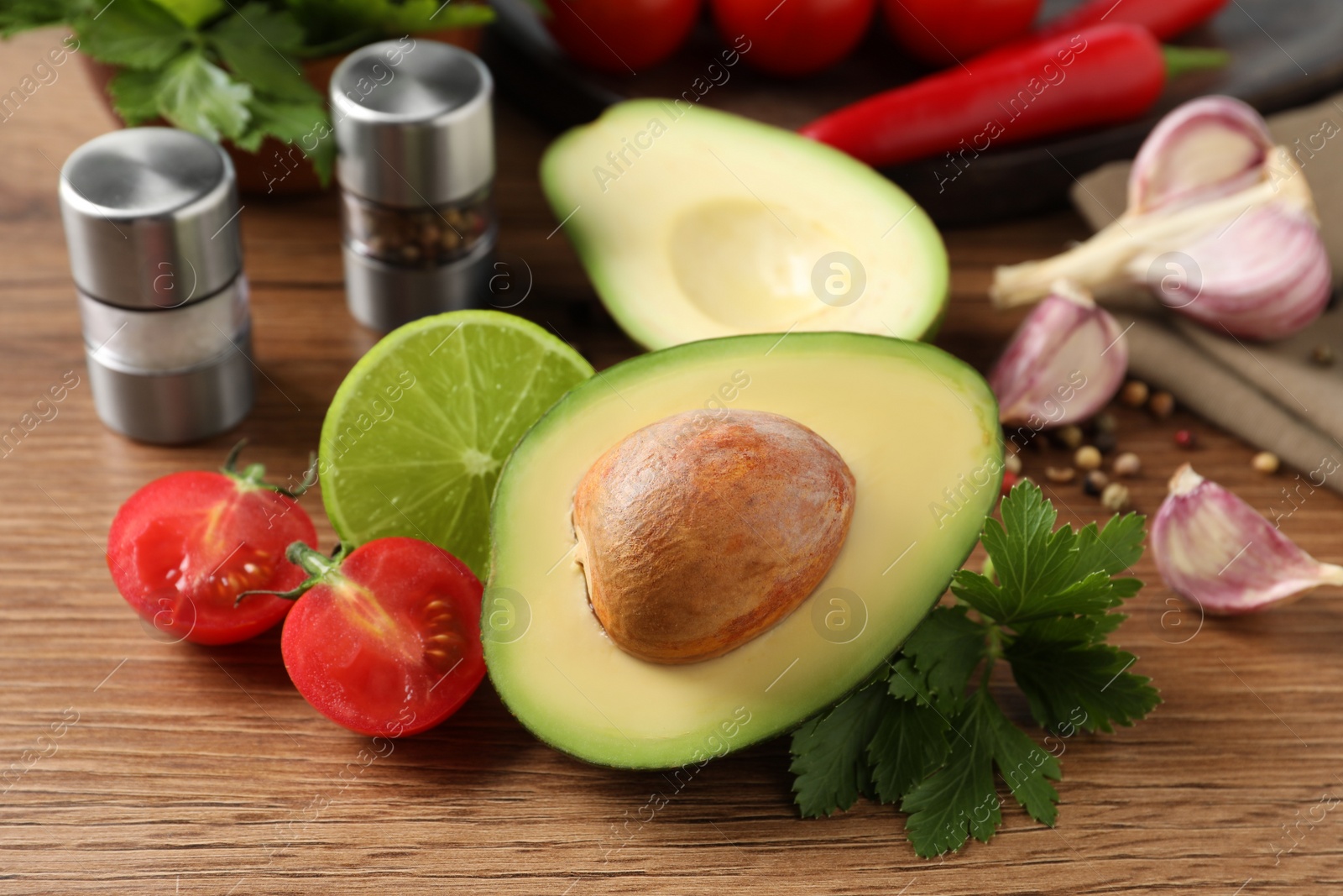 Photo of Fresh ingredients for guacamole on wooden table
