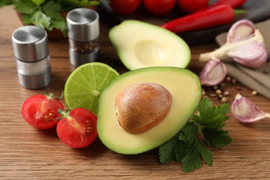 Fresh ingredients for guacamole on wooden table