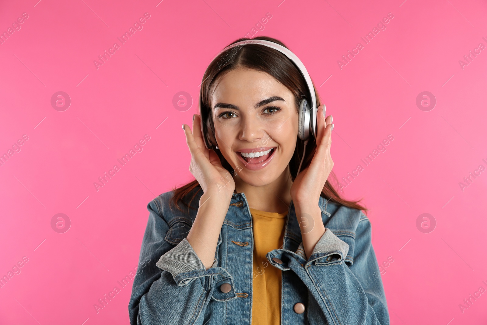 Photo of Beautiful young woman listening to music with headphones on color background